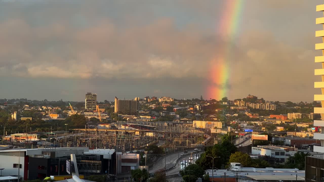 el cielo se aclara después de una fuerte lluvia por la tarde, un hermoso arco iris con un sol dorado brillando a través de las colinas de bowen, suburbio del interior de la ciudad de brisbane, sureste de queensland