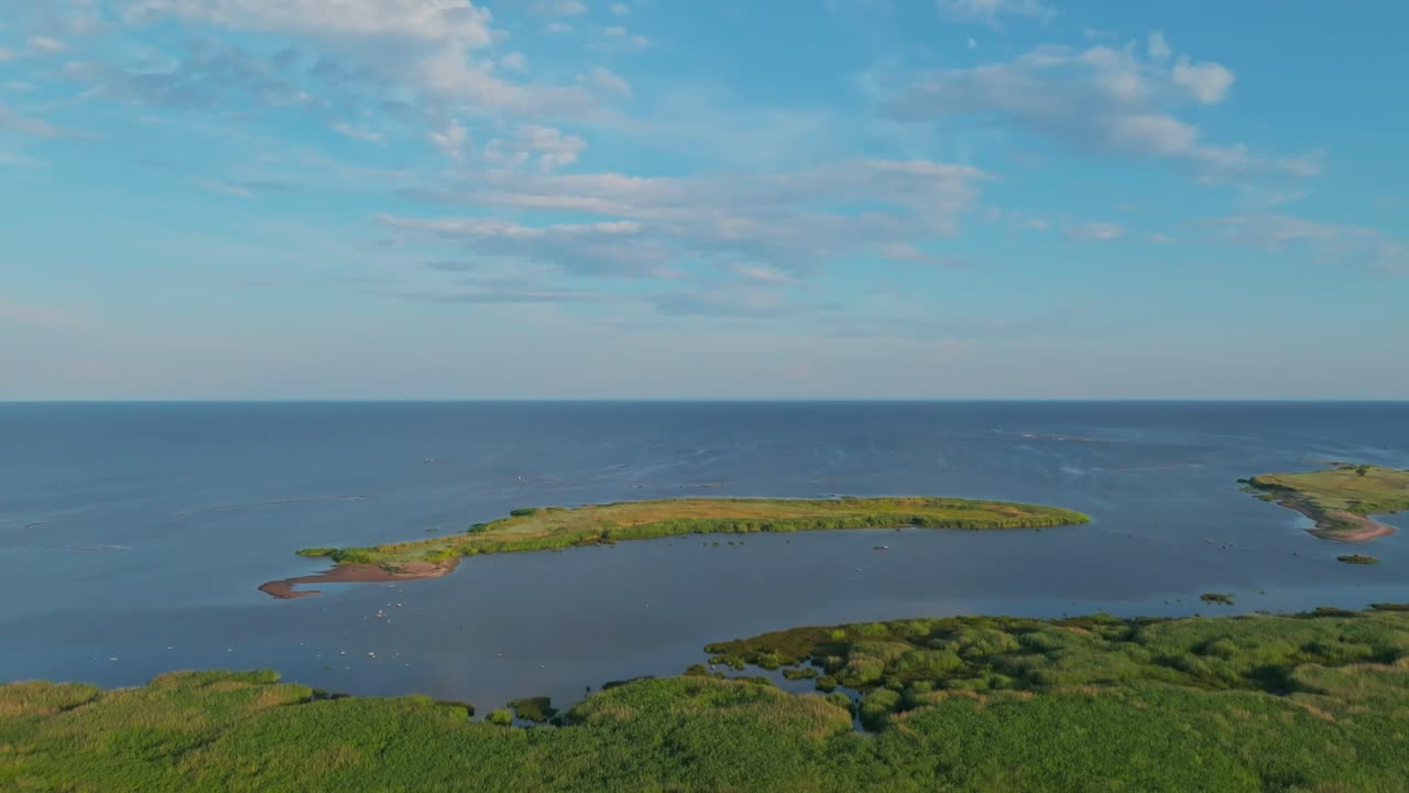 Two islets near the coast in summer sun, flying over forest, peaceful sea