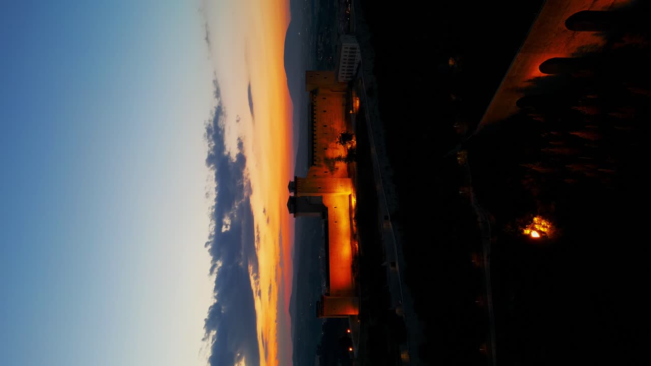 vista aérea de la fortaleza iluminada de rocca albornoziana con el cielo al atardecer en el fondo