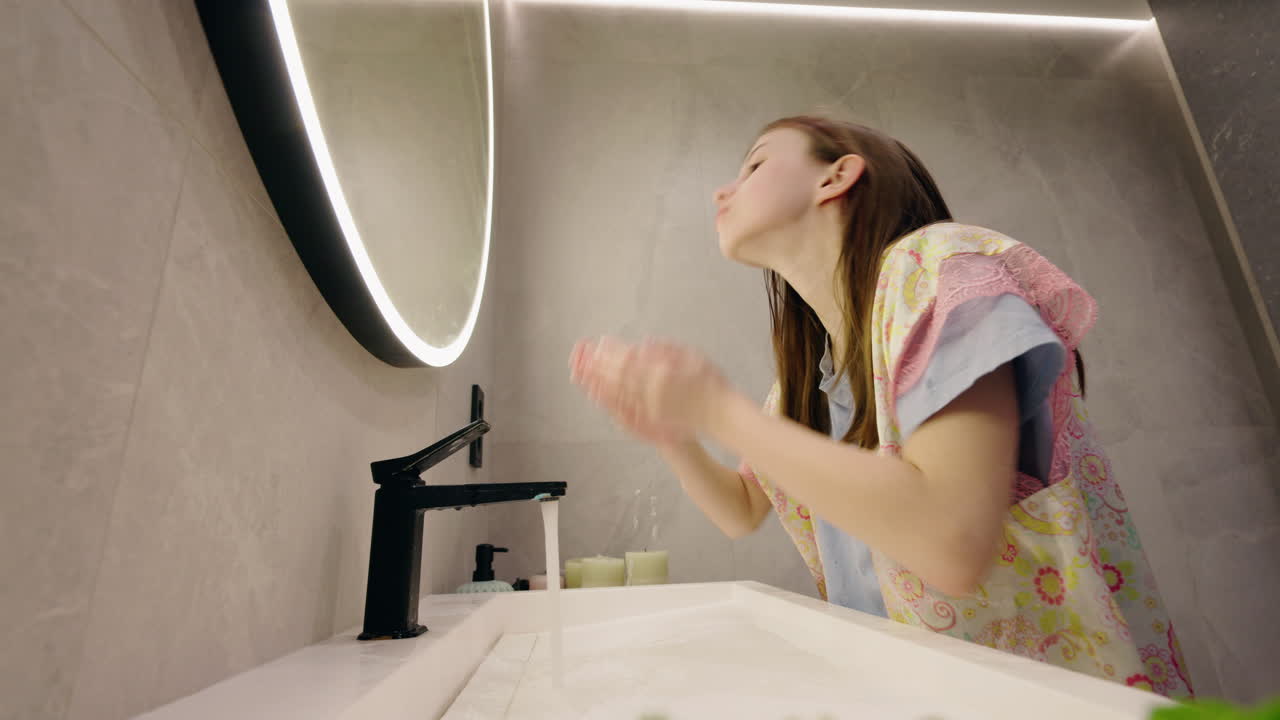 Girl washing her face in the bathroom