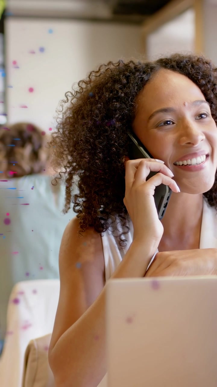 Video vertical: Trabajador de oficina sosteniendo un teléfono, creando una onda animada sobre un portátil para una llamada con un cliente.