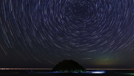 majestic spiral star trails over ocean with island.