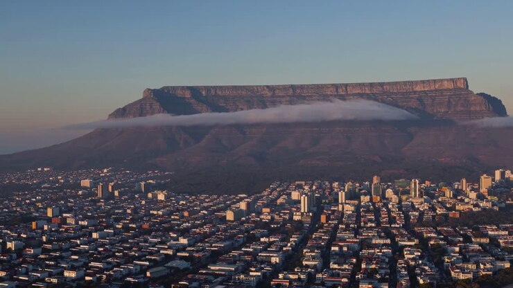 Vista aerea di un paesaggio urbano con un maestoso sfondo montano all'alba