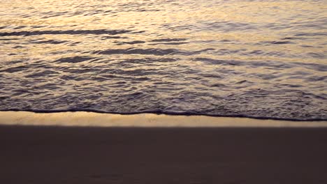 close up of waves washing ashore tropical hawaiian beach at sunset