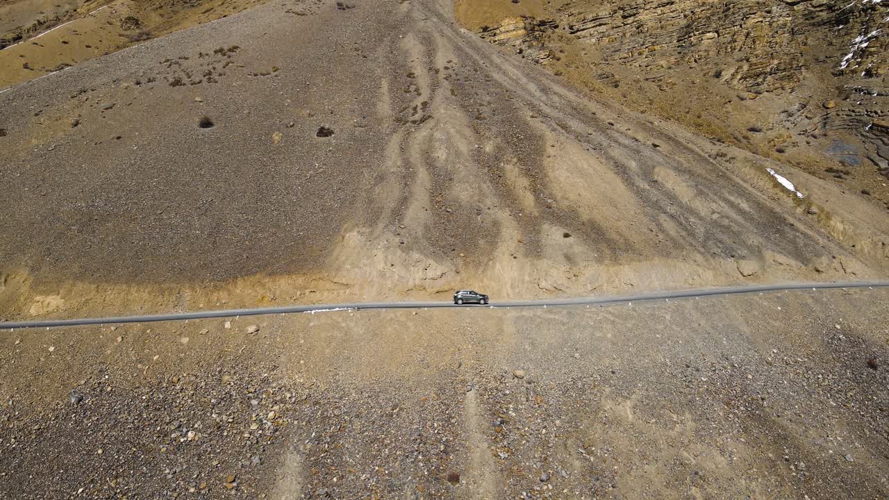 drone aéreo siguiendo el disparo de un coche que pasa por la montaña de arena en el valle de spiti, himachal pradesh, india