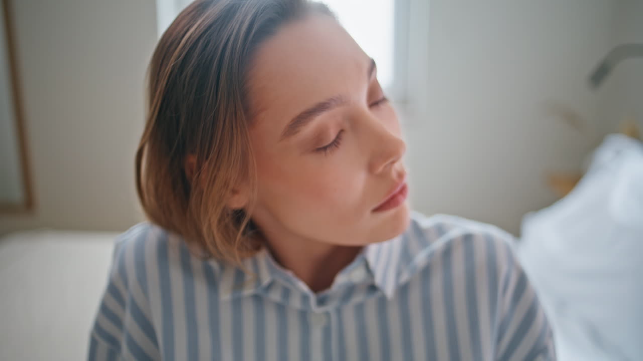 Closeup woman serious gaze in light room interior. Girl with big eyes