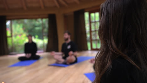 group of persons sitting on ground, practicing yoga meditation at shala temple, sacred valley peru