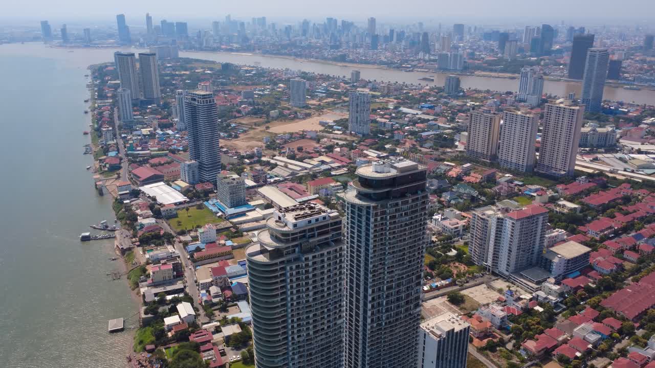 Phnom Penh city buildings and development on mekong river under hazy sky, smog due to air pollution and climate change, Drone shot