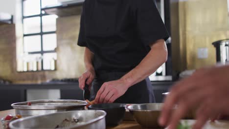 Caucasian-male-chef-cutting-vegetables