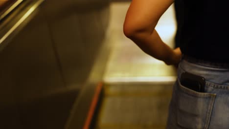 persona descendiendo por la escalera mecánica en el metro de hong kong