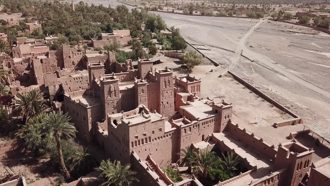 Ripresa aerea dall'alto che domina la storica Kasbah Taourirt a Ouarzazate. Il filmato rivela la disposizione complessa dei cortili interni, le mura fortificate e le torri di argilla di questo palazzo berbero.