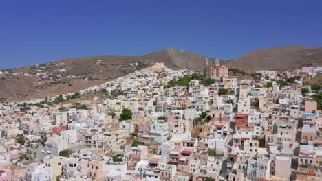 aerial: slow panning drone shot of resurrection of christ church in ermoupoli of syros island, greece on a sunny day