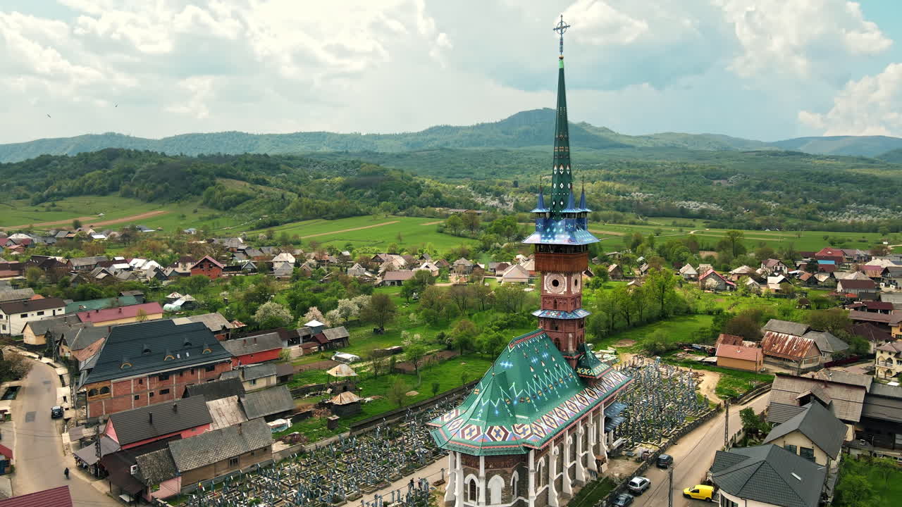 Letecký dronový pohled na Veselý hřbitov v rumunské obci Sapanta. Kostel a hřbitov, obytné budovy kolem něj