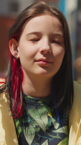 teenage girl sits on swing and closes eyes. child with rich imagination dreams of fantastic world smiling slightly closeup on blurred background