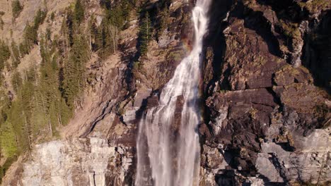 Aerial-drone-footage-orbiting-clockwise-with-stunning-views-of-a-picturesque-waterfall-in-Grindelwald-in-Switzerland