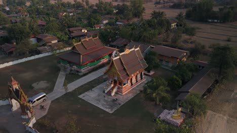 Pagoda-Tradicional-Con-Techo-Arqueado-En-El-Campo-De-Laoación,-Rotación-Aérea-De-Drones-Durante-La-Luz-Del-Sol-De-La-Tarde