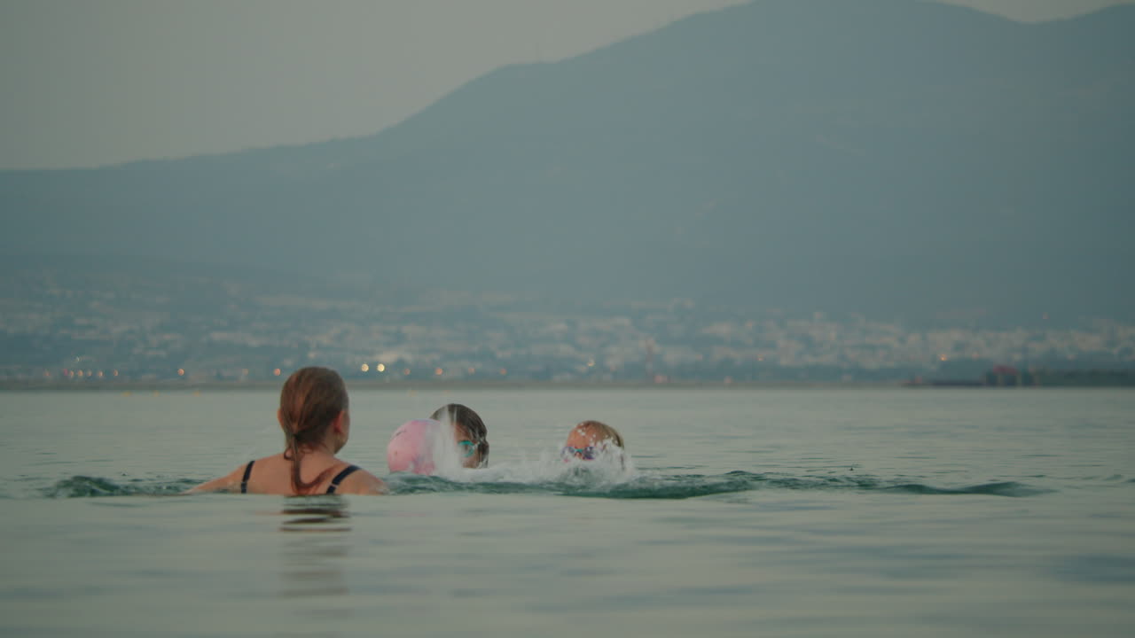 해가 지면 바다에서 공을 치는 가족