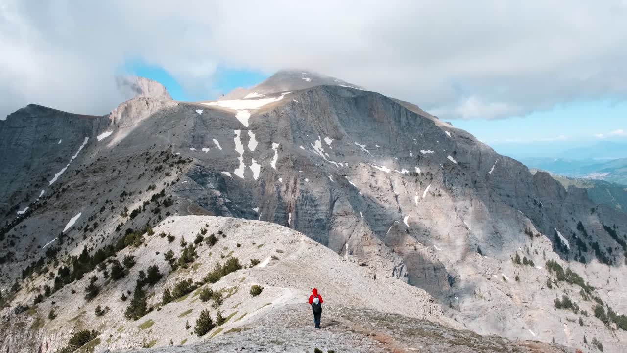 caminante cruza la meseta alpina en el monte olimpo en grecia - toma panorámica