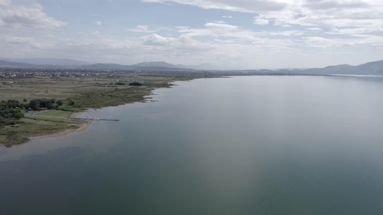 video con un dron sobre el lago skadar en albania, descendiendo del cielo hasta alcanzar el nivel del agua, sobrevolándolo