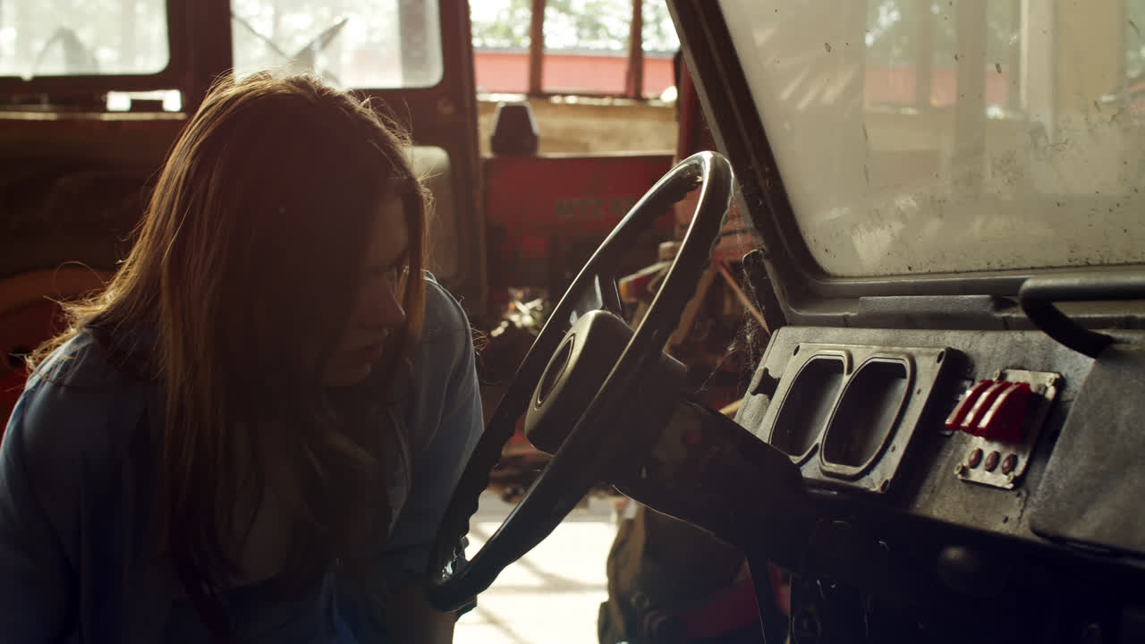 Woman inspecting a tractor in a barn