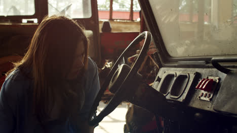 woman inspecting a tractor in a barn