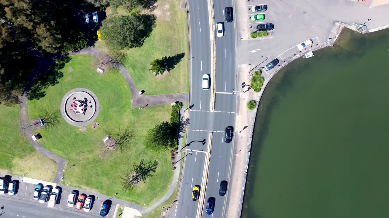 Drone aerial landscape of car vehicles driving on main road highway with pedestrian crossing and causeway at Gosford city waterfront boardwalk on the Central Coast Australia transport tourism outdoors