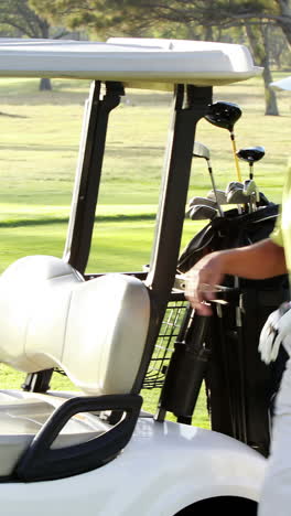 male golfer putting golf club in golf bag