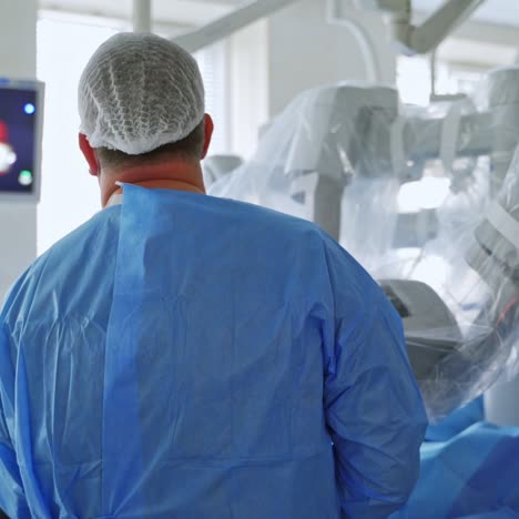 backside view of a surgeon looking on the monitor. robotic equipment perform an operation in the modern surgery room.