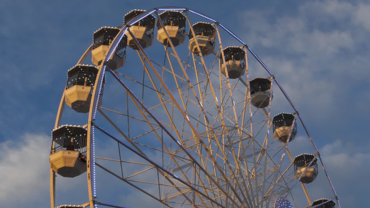 Ferris wheel in action againts a blue sky.