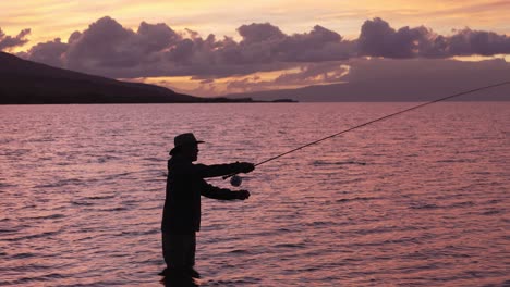 Slow-Motion-Is-Employed-To-Show-A-Full-Shot-Of-Fly-Fisherman-In-Silhouette-At-Sunset-In-Molokai,-Hawaii