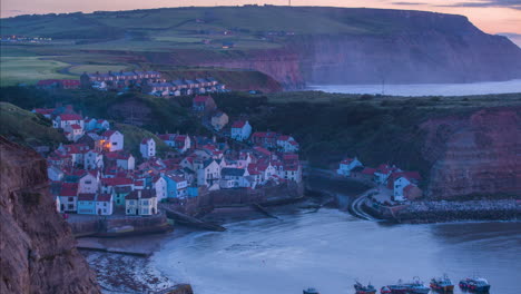 Staithes-Harbour-Y-Village-Timelapse-Desde-El-Promontorio-Con-Niebla-Hasta-El-Anochecer-Con-Las-Luces-Del-Pueblo-Iluminando,-Atmosférico