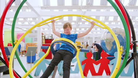 young boy having fun on human gyroscope at a science centre