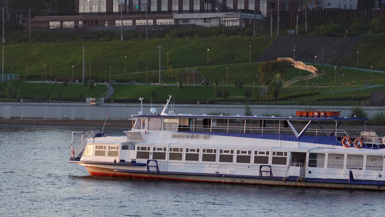Passenger Boat on a River Near an Urban Embankment