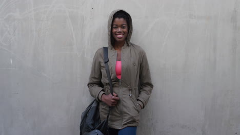 portrait happy young african american woman student laughing cheerful enjoying successful urban lifestyle independent black female concrete wall background