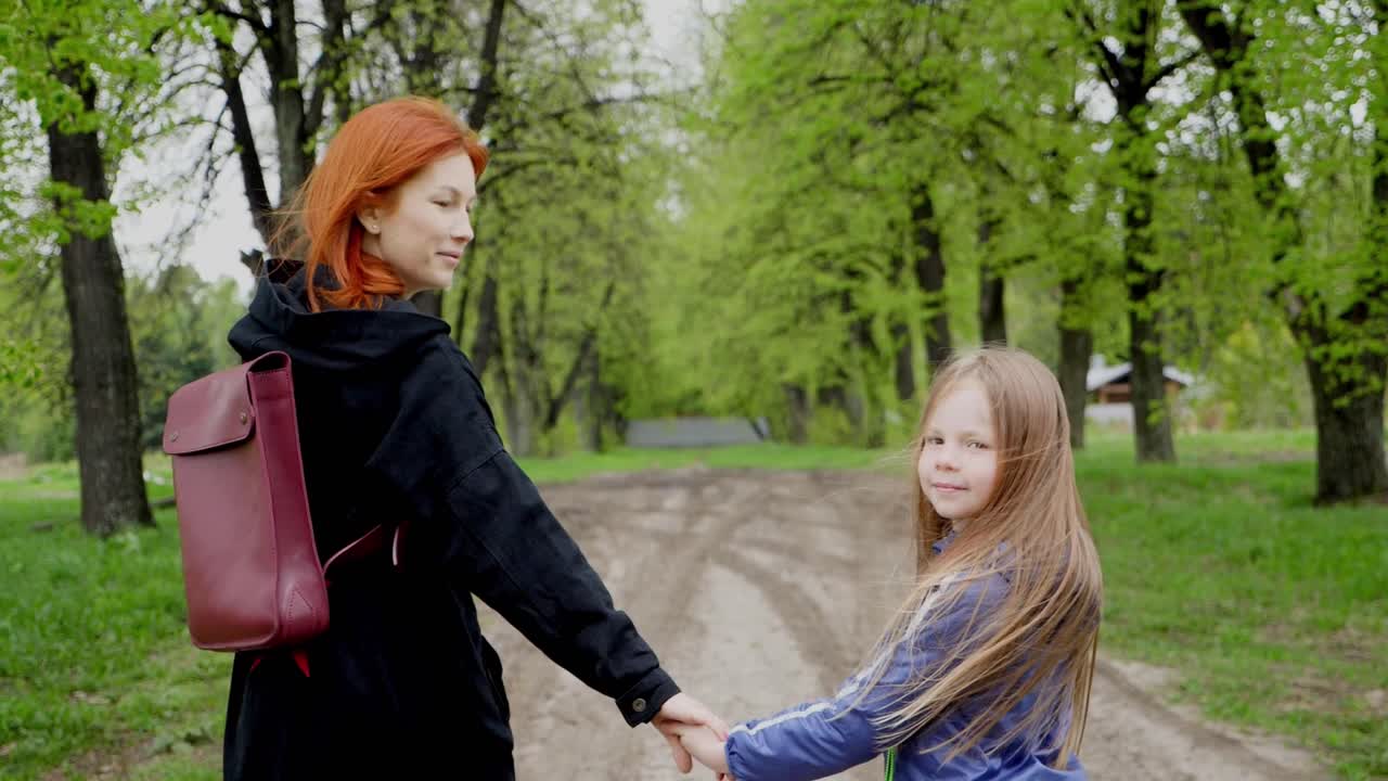 어머니 와 딸 이 공원 에서 산책 하고 있다
