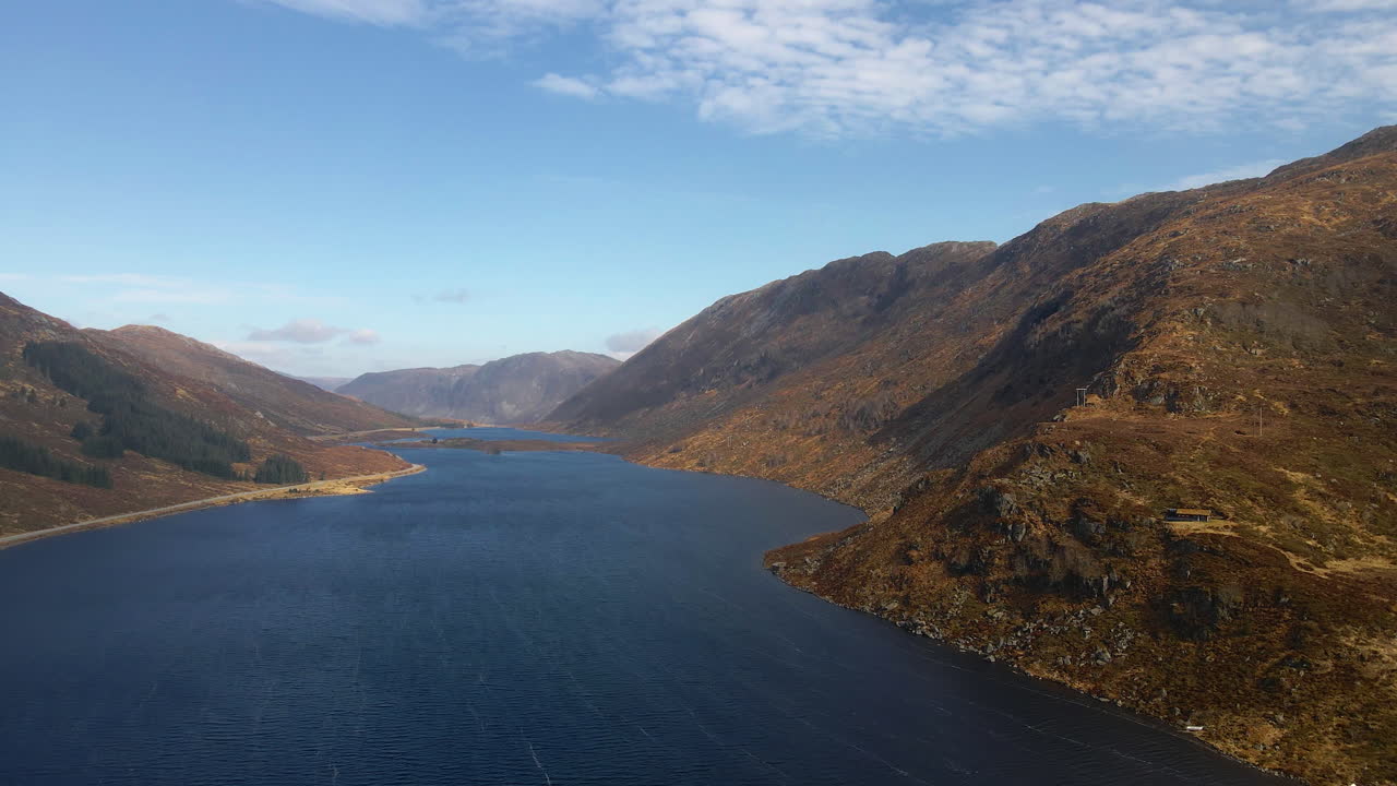 Scenic drone shot of mountainous landscape with a big lake in Norway on a bright sunny day