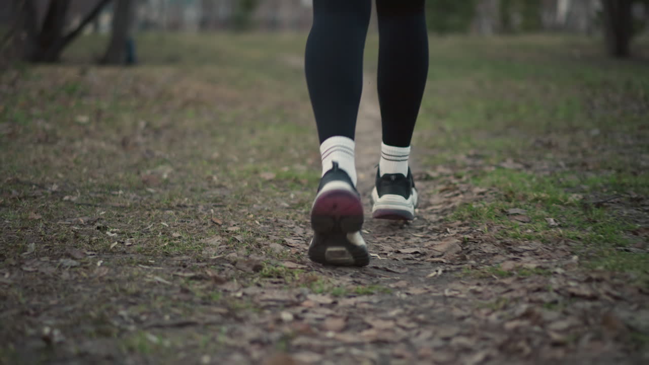 Female Individual Traversing Natural Trail Terrain, Girl Steps On Muddy Forest Trail With Visible Sock And Sole, Young Woman Takes Cautious Footstep Along Earthy Woodland Path With Mud And Leaf Litter