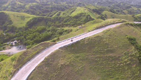 A-drone-shot-following-a-man-riding-a-scooter-near-the-boulder-beach-of-Batanes