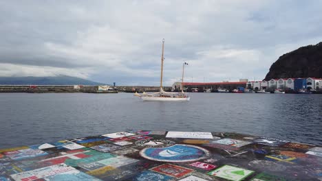 Boats-floating-in-the-harbor-in-Faial,-Azores-slowmotion-shot-,-Marina-with-wooden-vintage-vessel-parked-in-Açores-islands-on-a-overcast-day,-Portugal