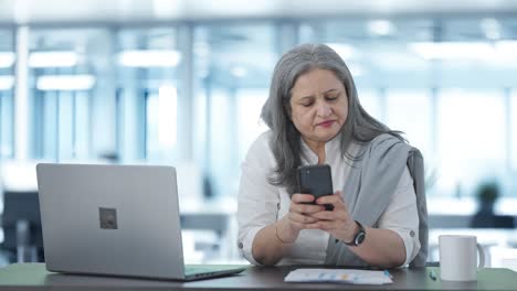 Indian-senior-female-manager-chatting-on-phone