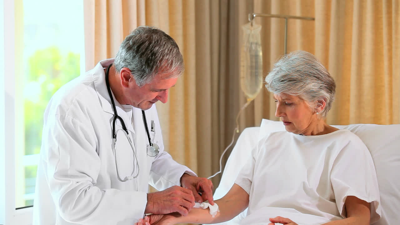 médico arreglando un dripfeed para el paciente en la cama del hospital