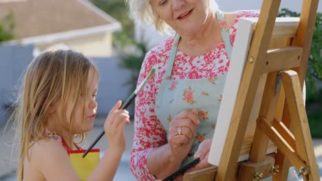 Granddaughter-and-grandmother-painting-on-canvas-4k