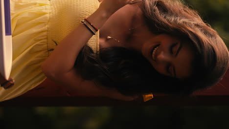 beautiful young brunette woman opens cooler box, surprised happy look, yellow dress, beautiful cinematic natural lighting, slow motion close up, vertical