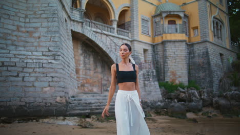 elegant woman posing near a castle on the beach