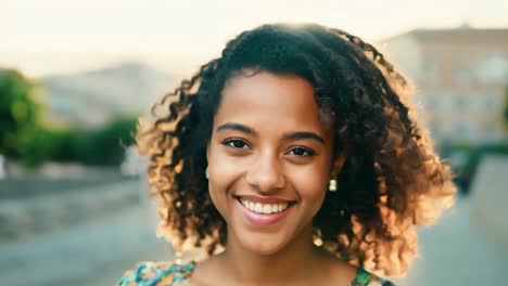 beautiful young woman with curly hair smiling in the city