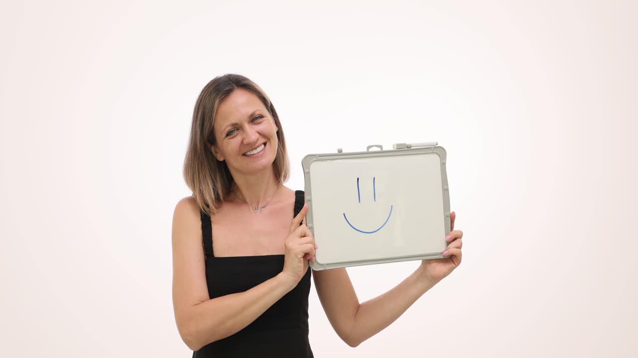 Woman holding whiteboard with a smile drawing