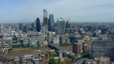 drone shot of city of london business district skyscrapers from south of the river thames