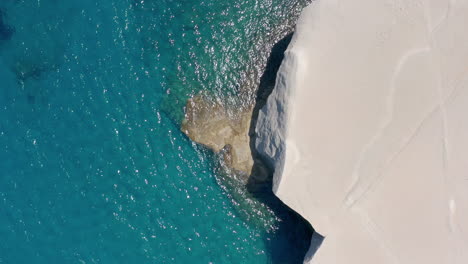 Aerial:-Top-down-drone-shot-of-white-rocks-and-turquoise-water-on-Sarakiniko-Beach-in-Milos-Island,-Greece