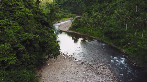 aerial-scientific-observatory-shot-of-river-samples-on-riverbank-flowing-in-s-shaped-form-in-a-valley-between-lush-thick-forest-mountains-never-visited-by-greedy-capitalists-because-of-danger