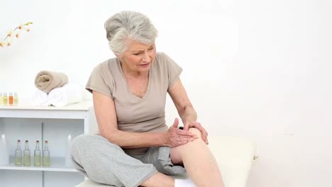 injured patient rubbing her painful knee